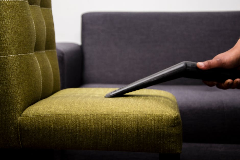 Close-up of a clean wooden surface with a subtle shine, reflecting soft natural light from nearby windows in a well-lit room. The surface appears dust-free and polished, with a cloth and spray bottle